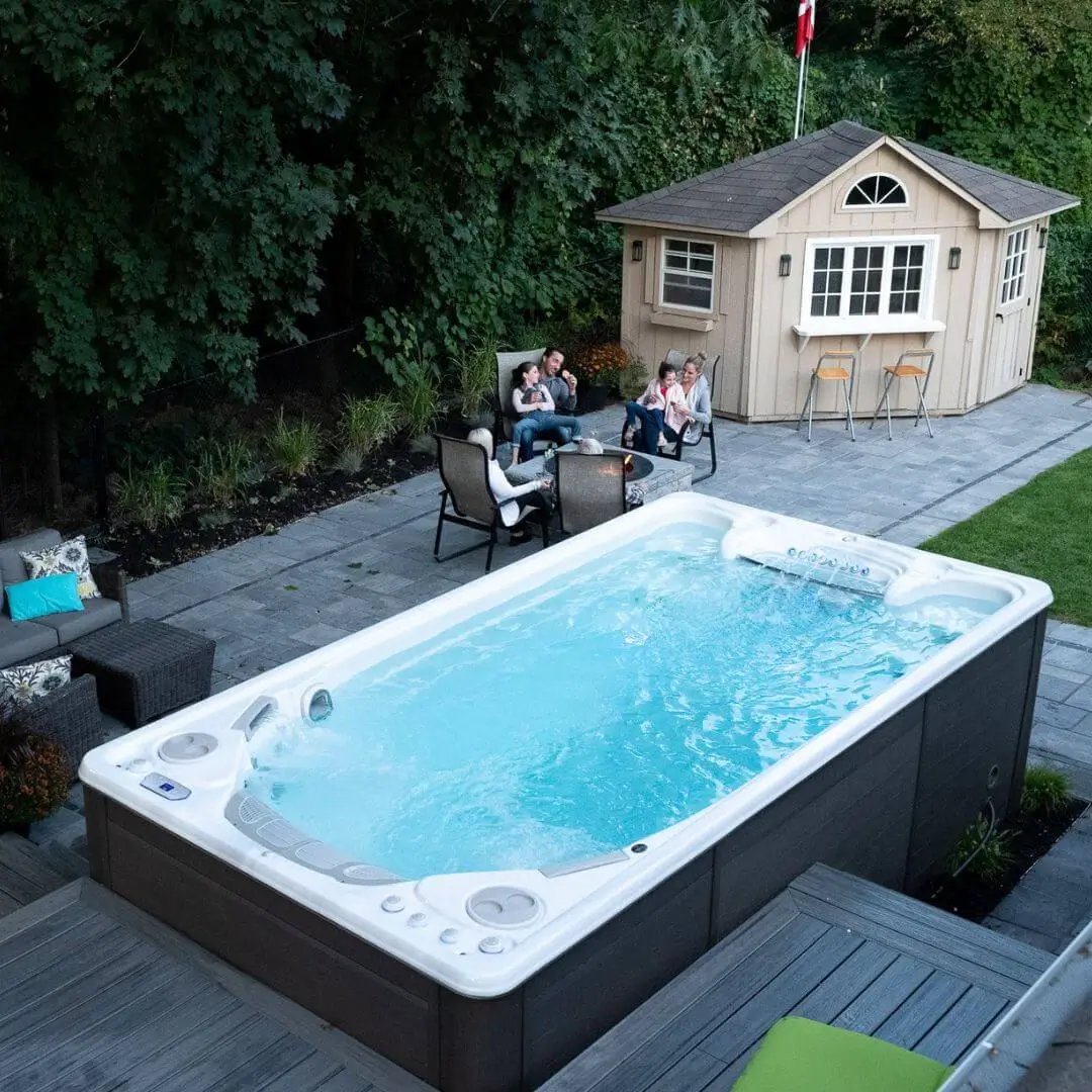 hydropool midlands swim spa in garden with timber decking area and patio and deck chairs and garden building 