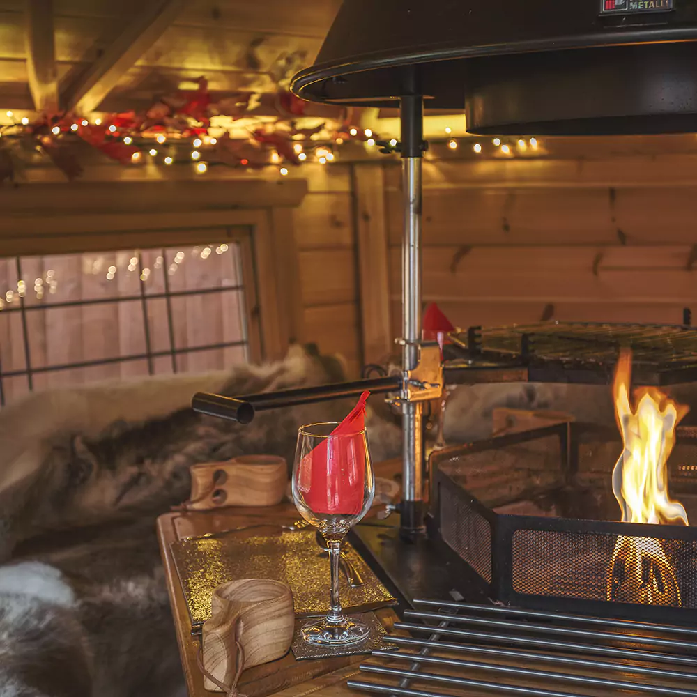 Interior a BBQ hut with fire lit & wine glasses on table