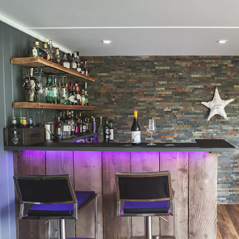 Inside a garden bar with pool table and shelving unit with brightly coloured accessories