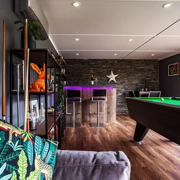 Interior of garden bar shed with bar, pool table, bar stools and shelving