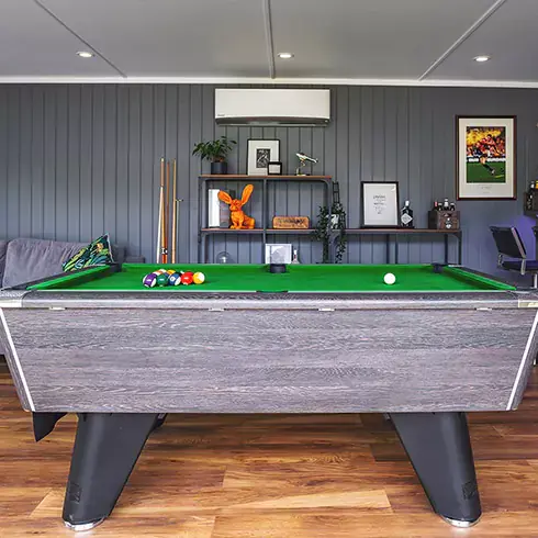 a garden man cave room with a pool table and large flat screen television in it