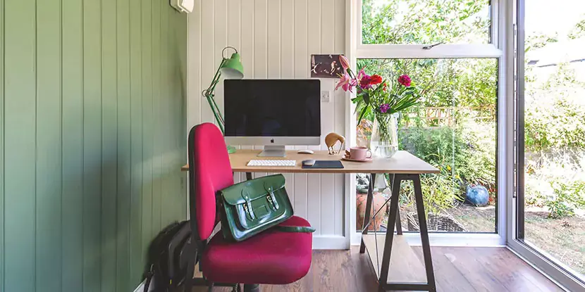 Interior of a small garden office with desk and computer 