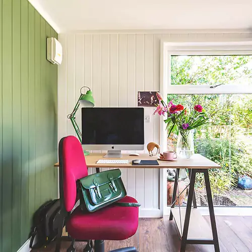 Looking through doors of a small garden office towards desk area