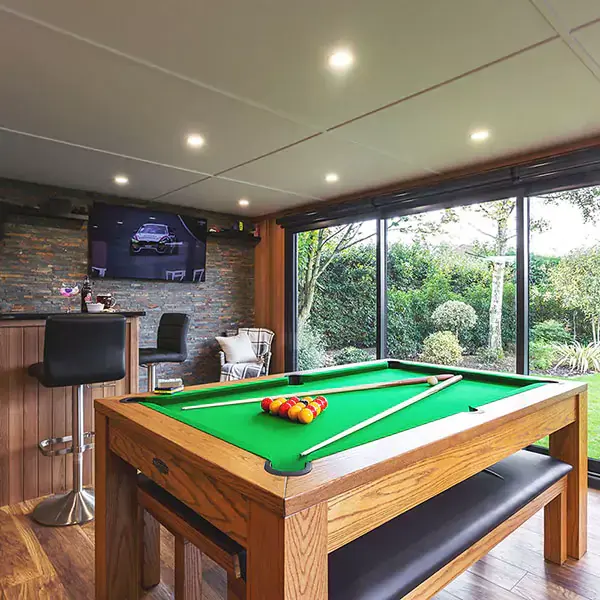 large pool table with bar and stools and tv 