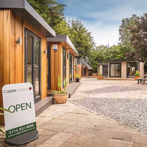 Cabin Master garden rooms show site in Nottingham, looking into the entrance with 'open' sign on the floor near the gate