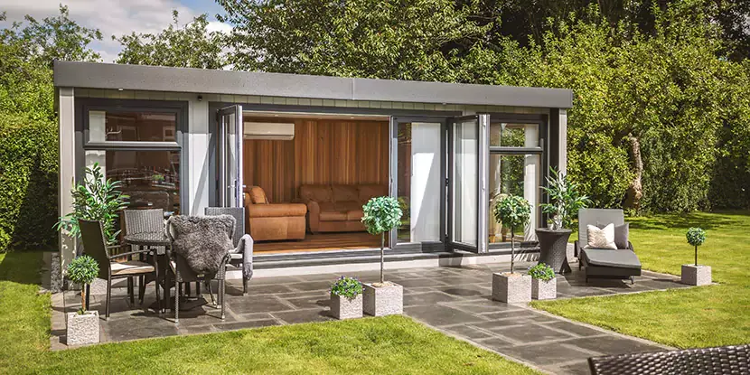 Outside looking in to a luxury garden bar with open bifold doors 