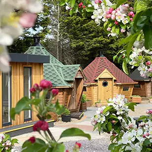 inside view of show site lodge annexe and rattan side tables with lampshades and grey feature wall and leather armchair