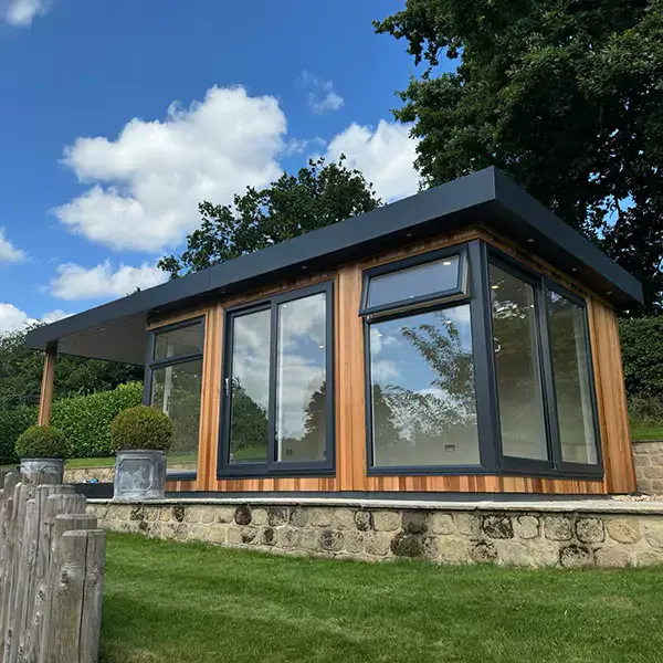 Show Site Veranda Room cedar Cladding garden building with veranda and hydropool midlands hot tub and view into building with grey and yellow home furnishings  