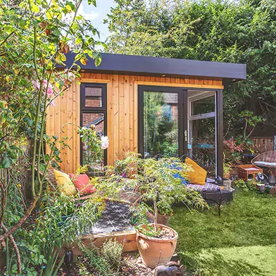 Small timber garden office with bright decor outside