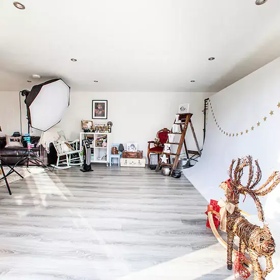 Internal of a Newborn photography studio with shelving, sofa and prints on wall