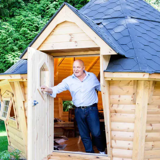 Aldo Zilli coming out of his Arctic BBQ Cabin smiling